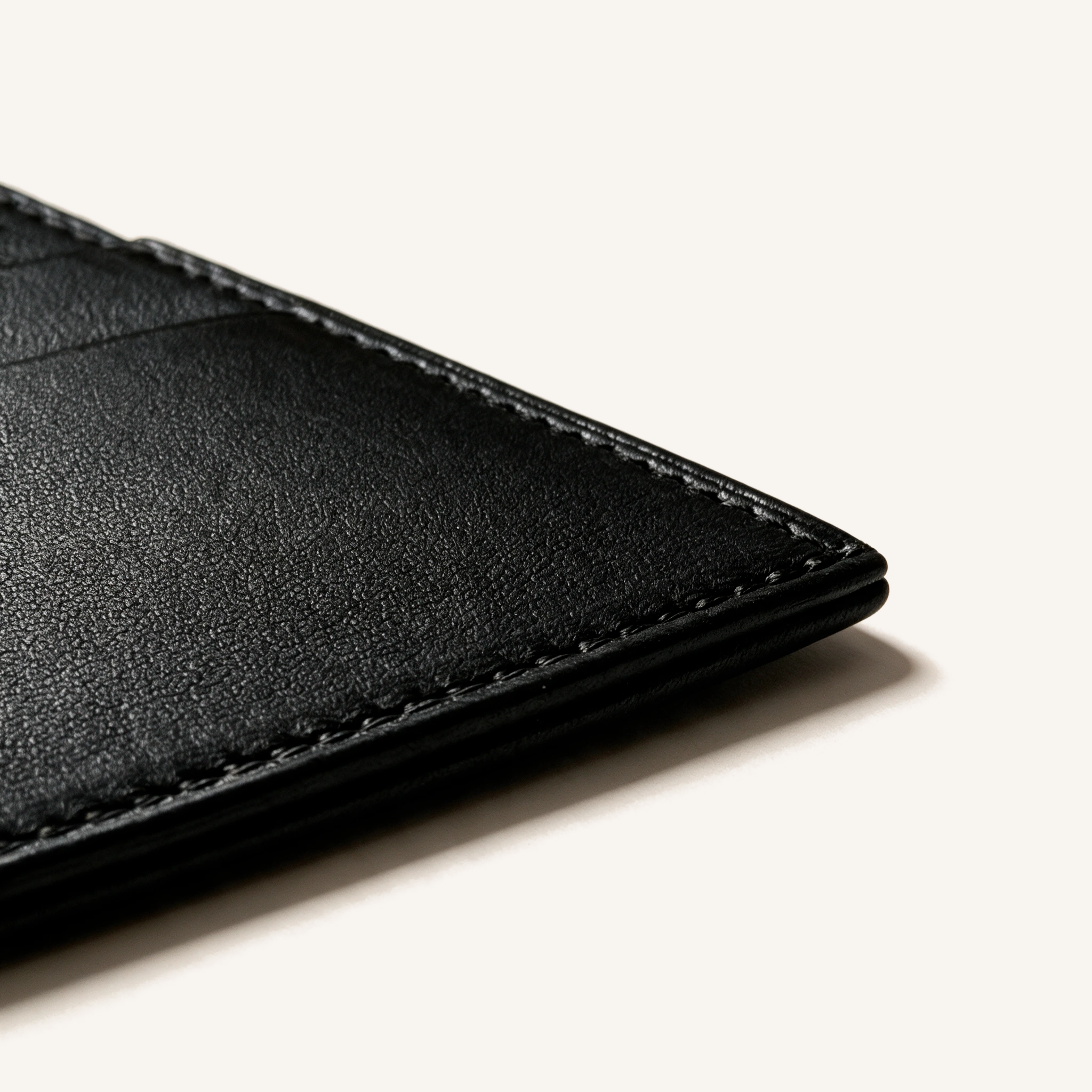 Détail du coin inférieur du porte-cartes OSZI First Touch en cuir d'agneau noir