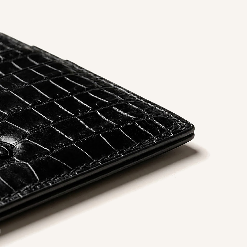 Détail du coin inférieur du porte-cartes OSZI First Touch en cuir d'alligator noir