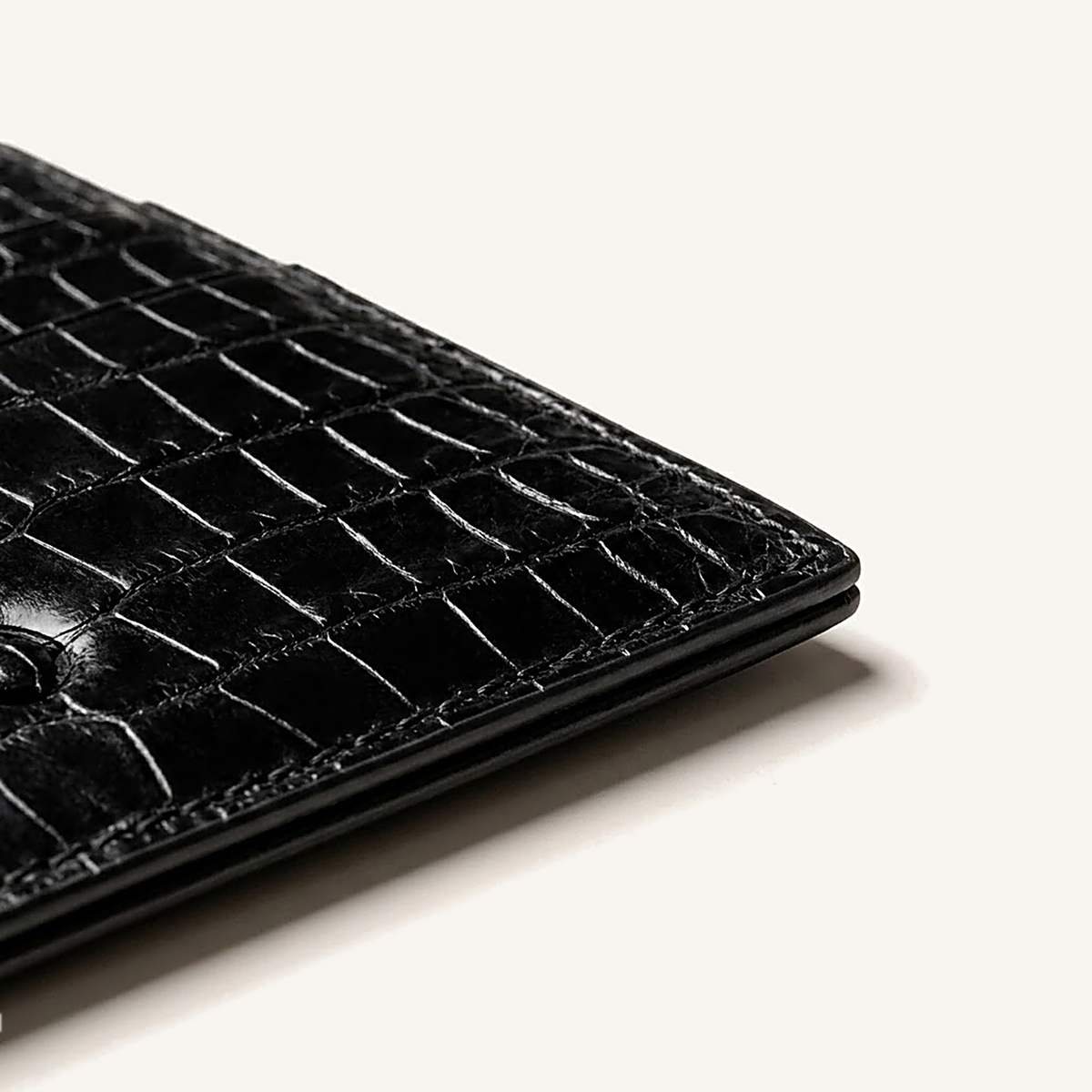 Détail du coin inférieur du porte-cartes OSZI First Touch en cuir d'alligator noir
