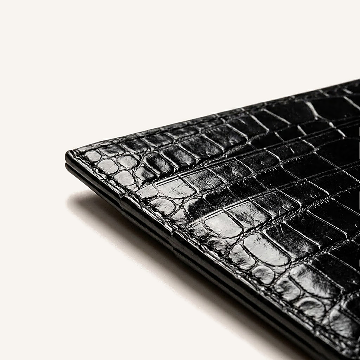 Détail du coin supérieur du porte-cartes OSZI First Touch en cuir d'alligator noir